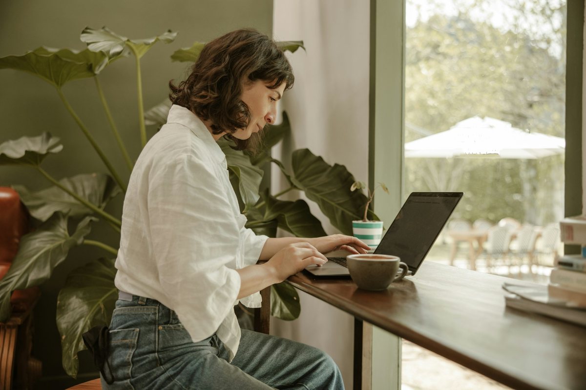 Administradora trabajando en su laptop junto a una ventana