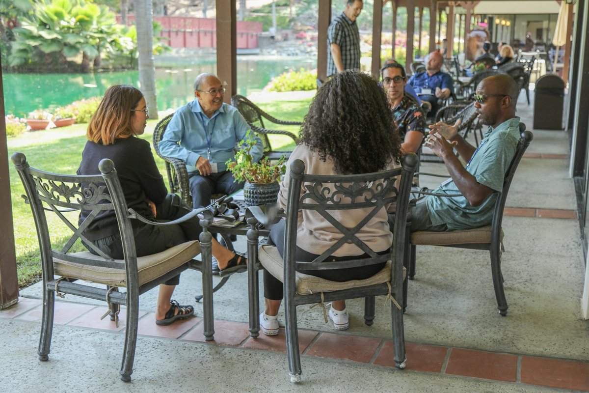 Vecinos reunidos en la terraza de un área común, conversando alrededor de una mesa